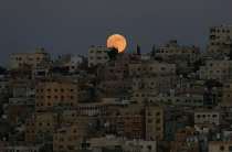The moon hovers above the city of Amman, Jordan. Photograph: Muhammad Hamed/Reuters
