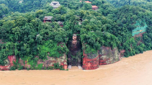 O statuie uriașă a lui Buddha a ajuns cu degetele în apă în urma inundațiilor masive. Imaginile care arată cât de mult a crescut apa