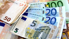 Dolarul se ieftinește, iar euro își menține cotația 